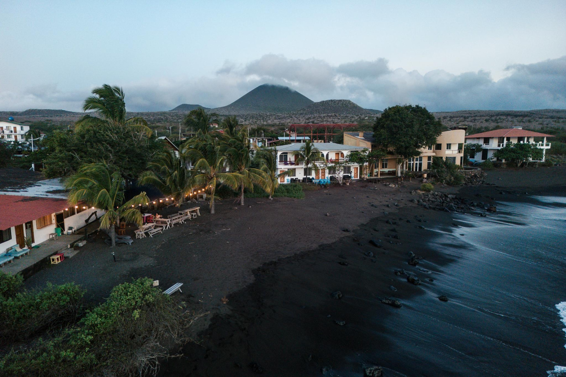 Aerial view of Floreana's black sand shoreline at dusk