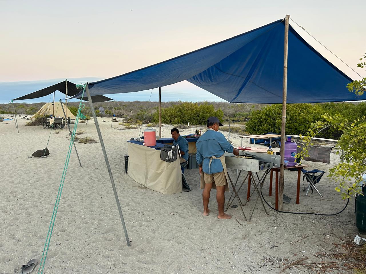 Camp field kitchen under a blue tarp